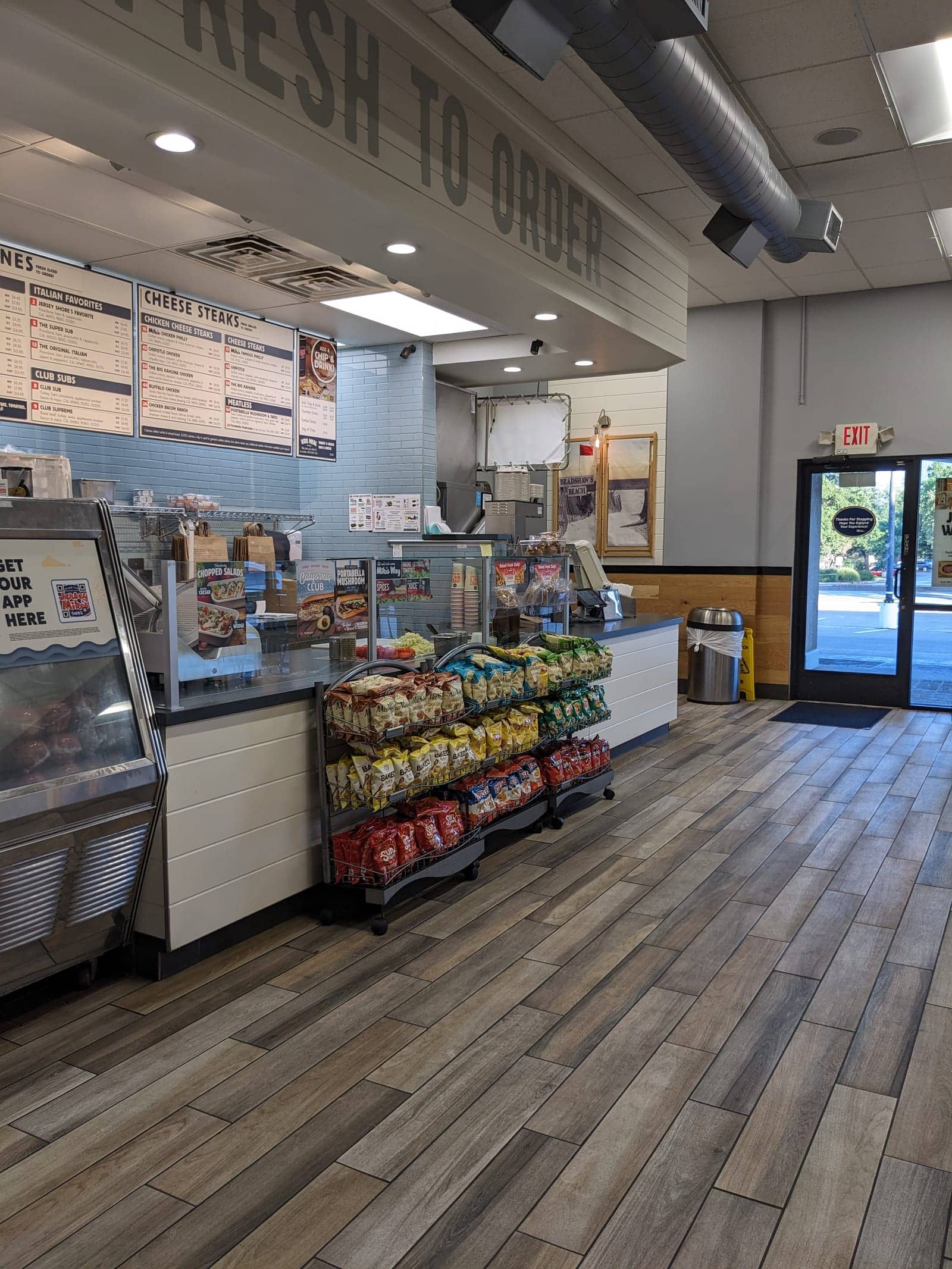 Jersey Mike's order counter interior with menu boards and shelves of chips and desserts