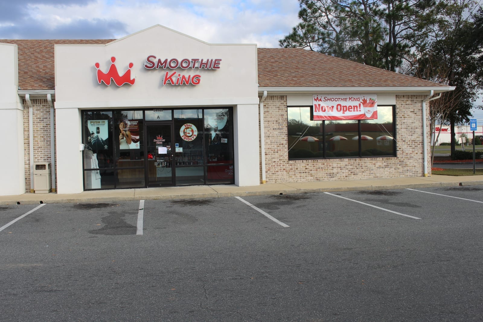 Smoothie King storefront exterior with red crown logo and signage, part of a shopping center strip