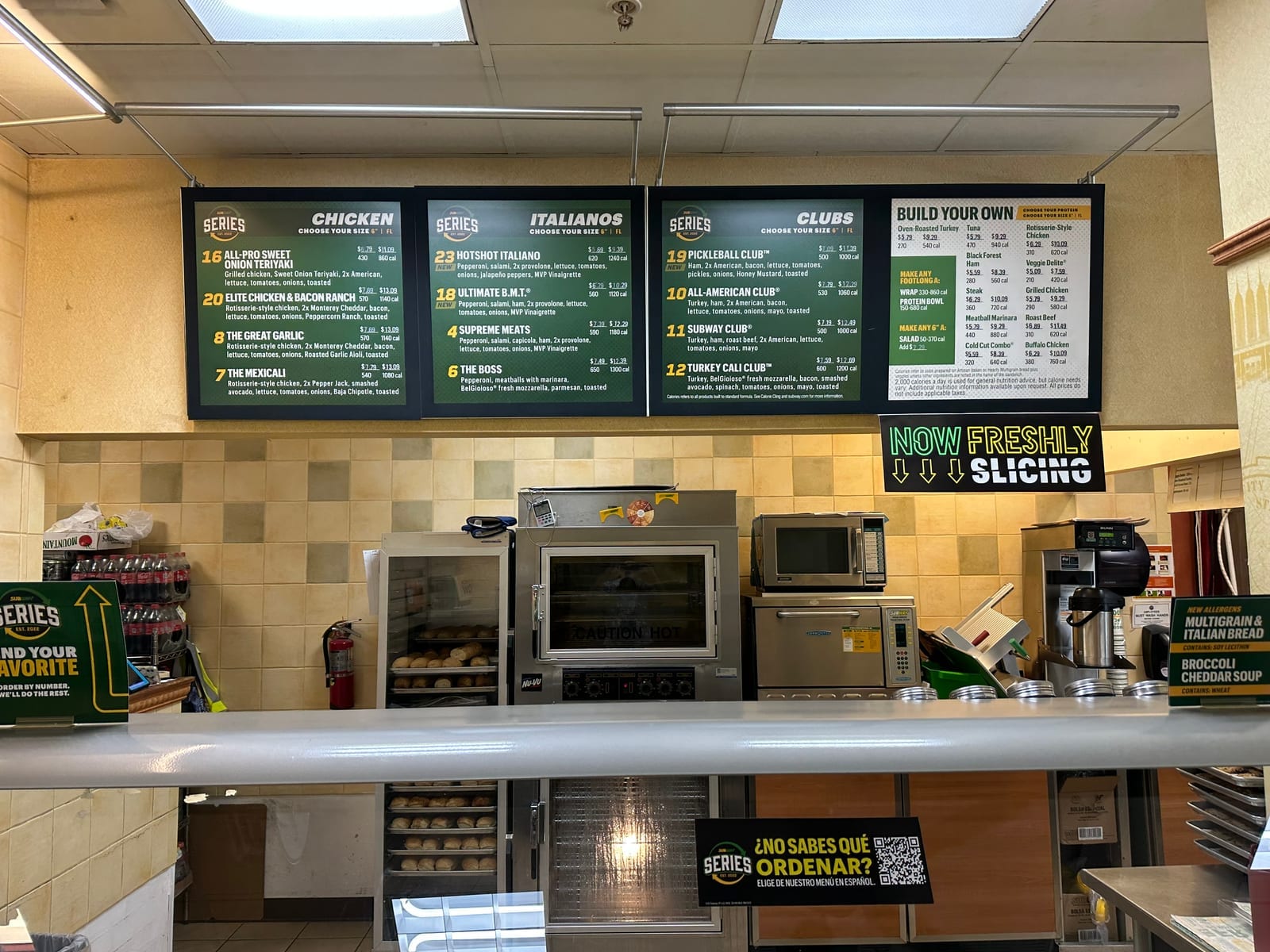Subway order counter with overhead menu boards, a bread oven, and food-prep equipment