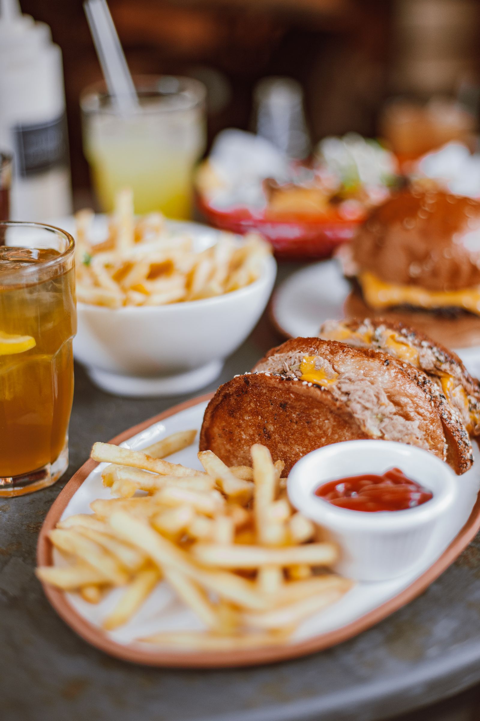 A burger and a plate of fries with a dip, served at a diner